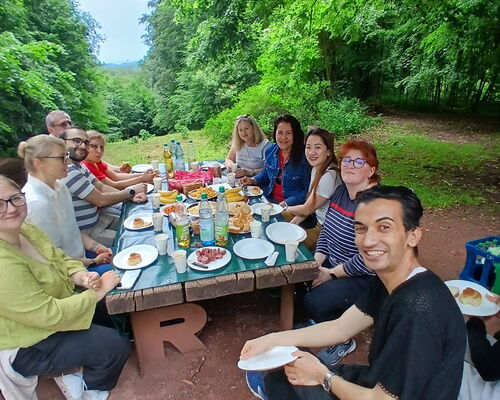 Gruppenbild: Personen unterschiedlicher Nationalität beim Picknick auf dem Rennsteig