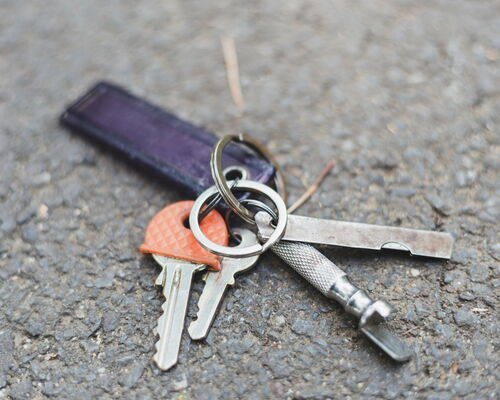 ein Schlüsselbund liegt auf dem Asphalt, offenbar wurde er verloren