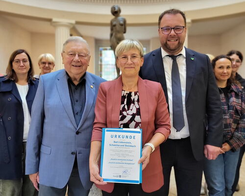 Susanne Rakowski präsentiert Urkunde, daneben Dr. Sigurd Scholze und Staatssekretär Marcus Malsch