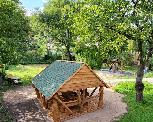 Ein Platz mit Hütte, Bänken, Tischtennisplatte