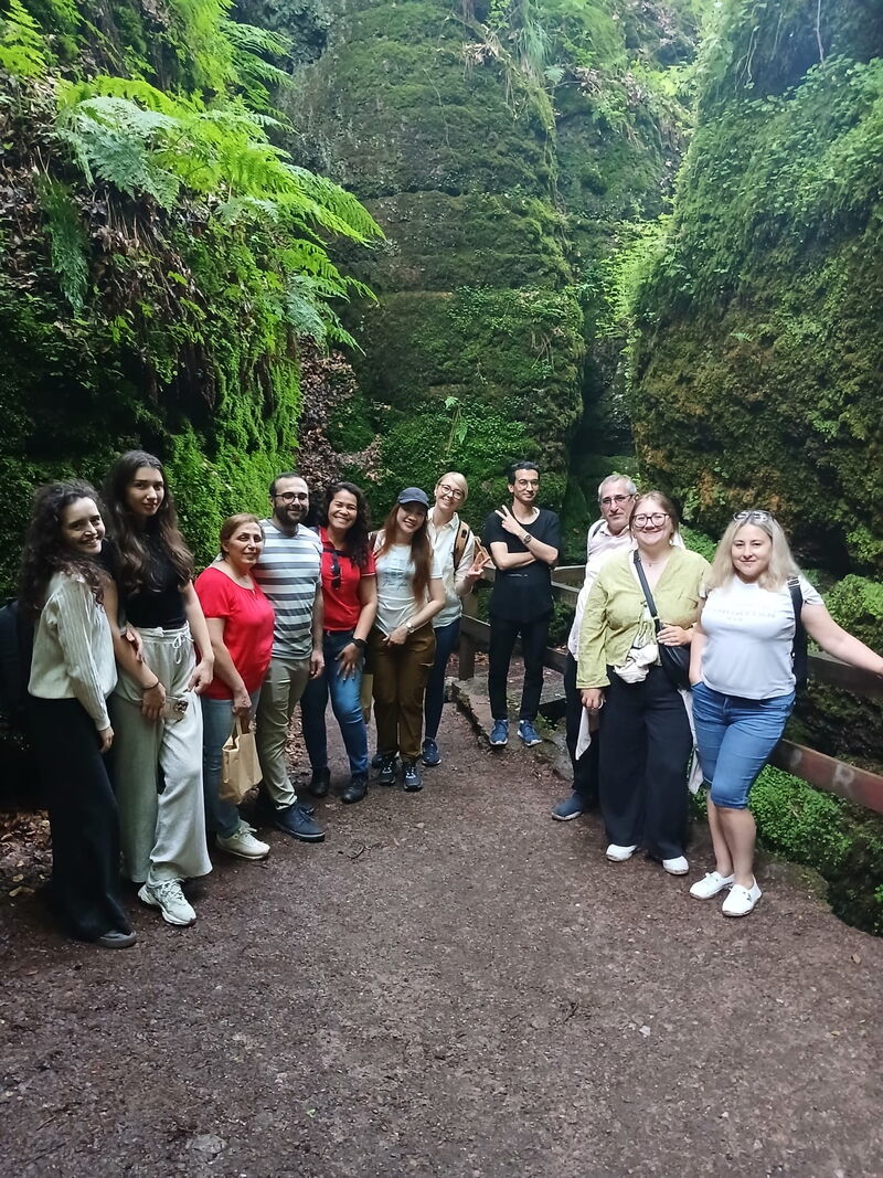 Gruppenbild: Personen unterschiedlicher Nationalität vor Felsenkulisse