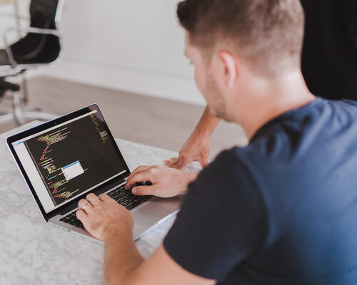 Mann an Laptop beim Programmieren