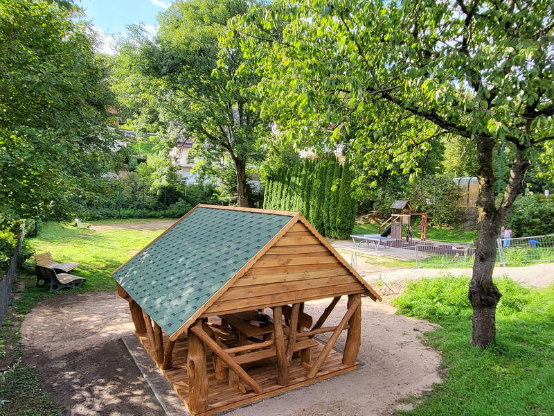 Ein Platz mit Hütte, Bänken, Tischtennisplatte