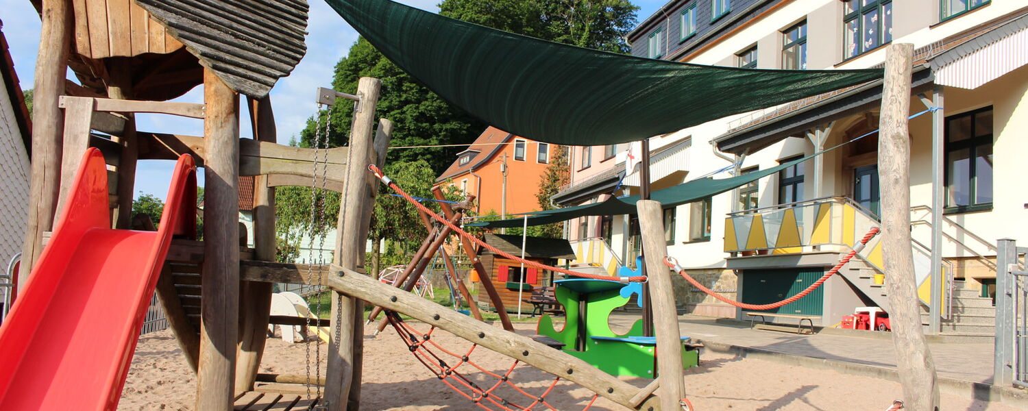 Klettergerüst mit Rutsche auf dem Spielplatz des Kindergarten Steinbach