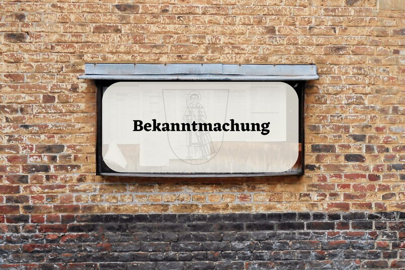 Ziegelsteinwand mit Anschlagtafel: Text Bekanntmachung