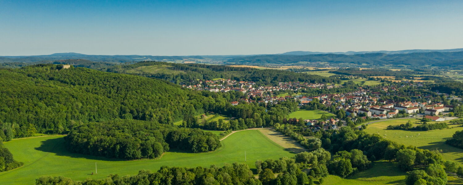 Landschaftsaufnahme mit Blick auf Bad Liebenstein und Burgruine, umgeben von Wald und Natur