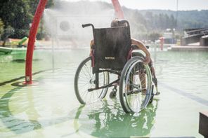 Rückansicht von Jungen im Rollstuhl im Wasser