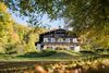 Villa im Schweizer Stil steht in einem weitläufigen Park mit vielen Bäumen