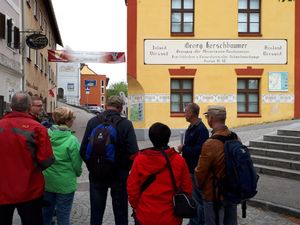 Rückenansicht mehrerer Personen vor Museumsgebäude und enger Dorfgasse in Steinbach an der Steyr