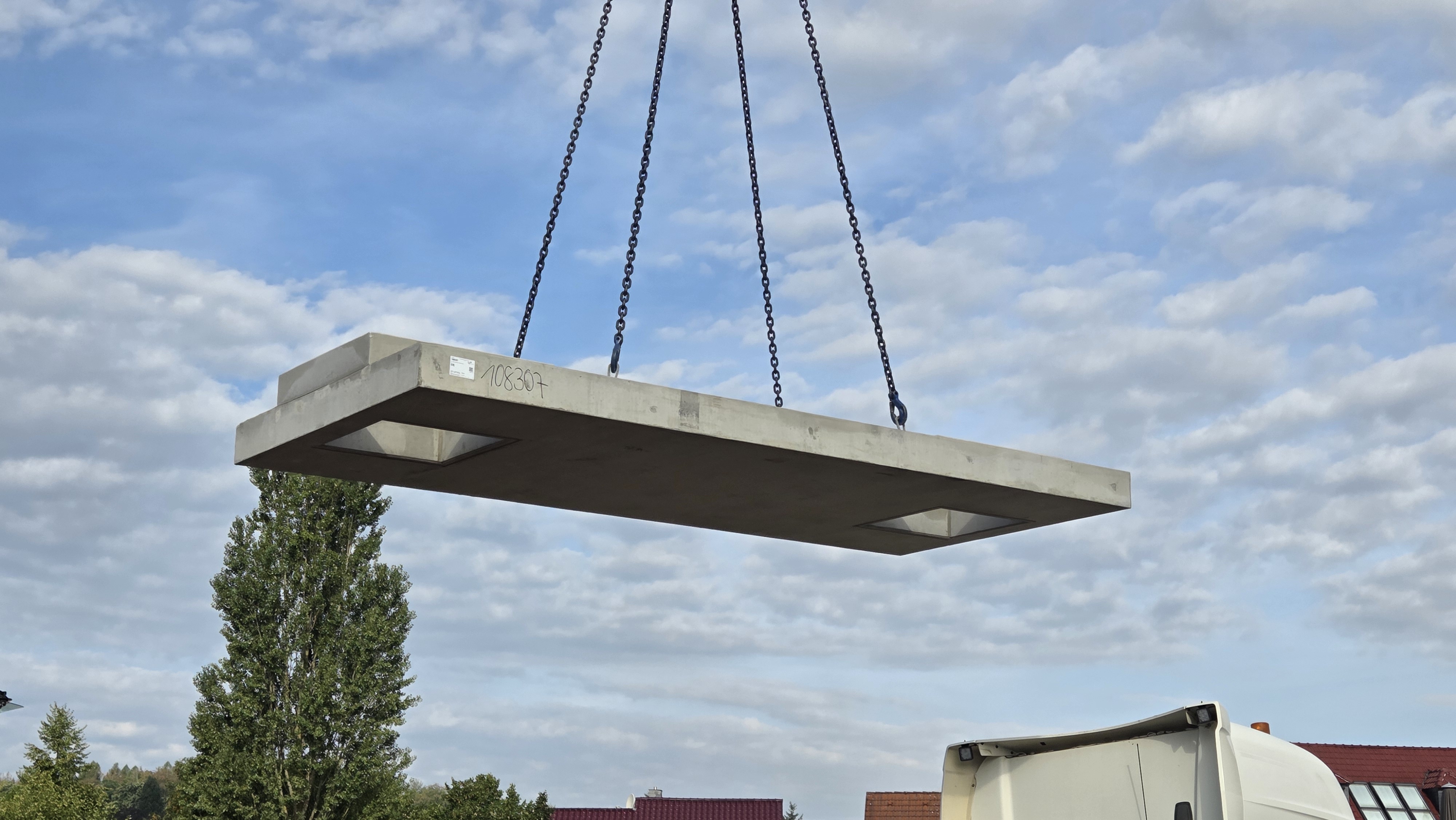 flaches Betonteil als Abdeckung für die Brunnenkammer hängt in der Luft