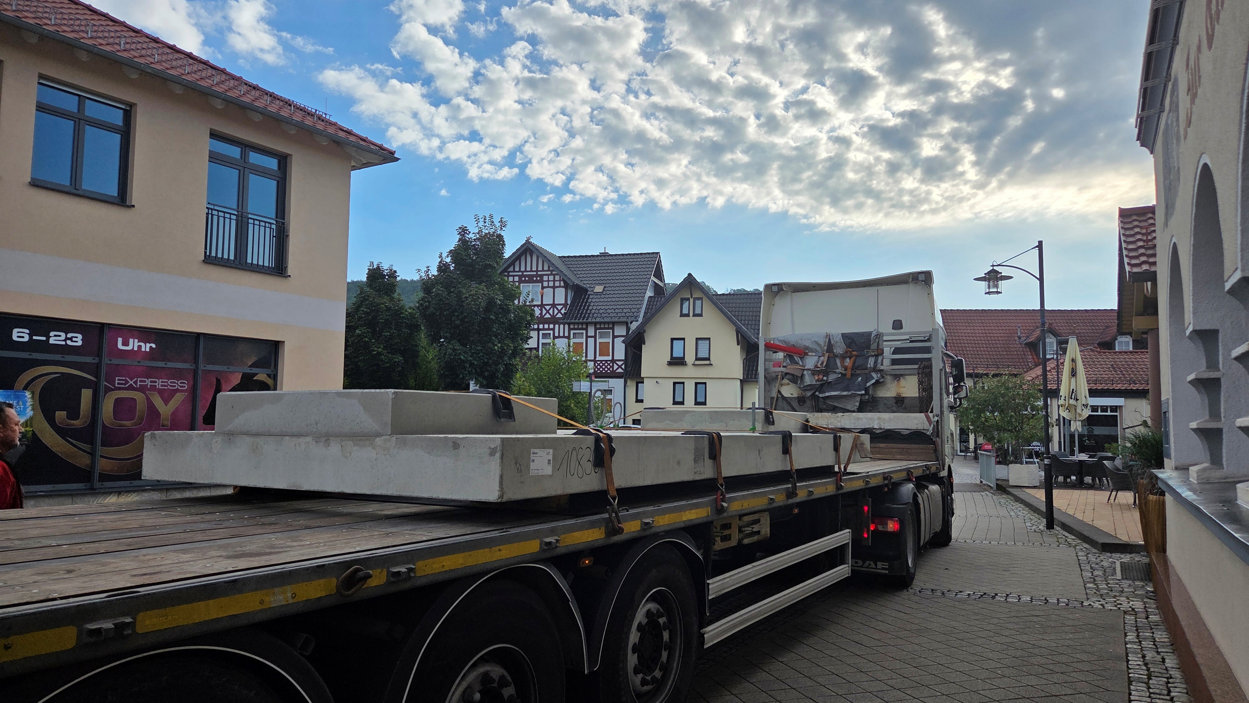 Tieflader mit Betonteil steht auf Straße und wartet auf Weiterfahrt