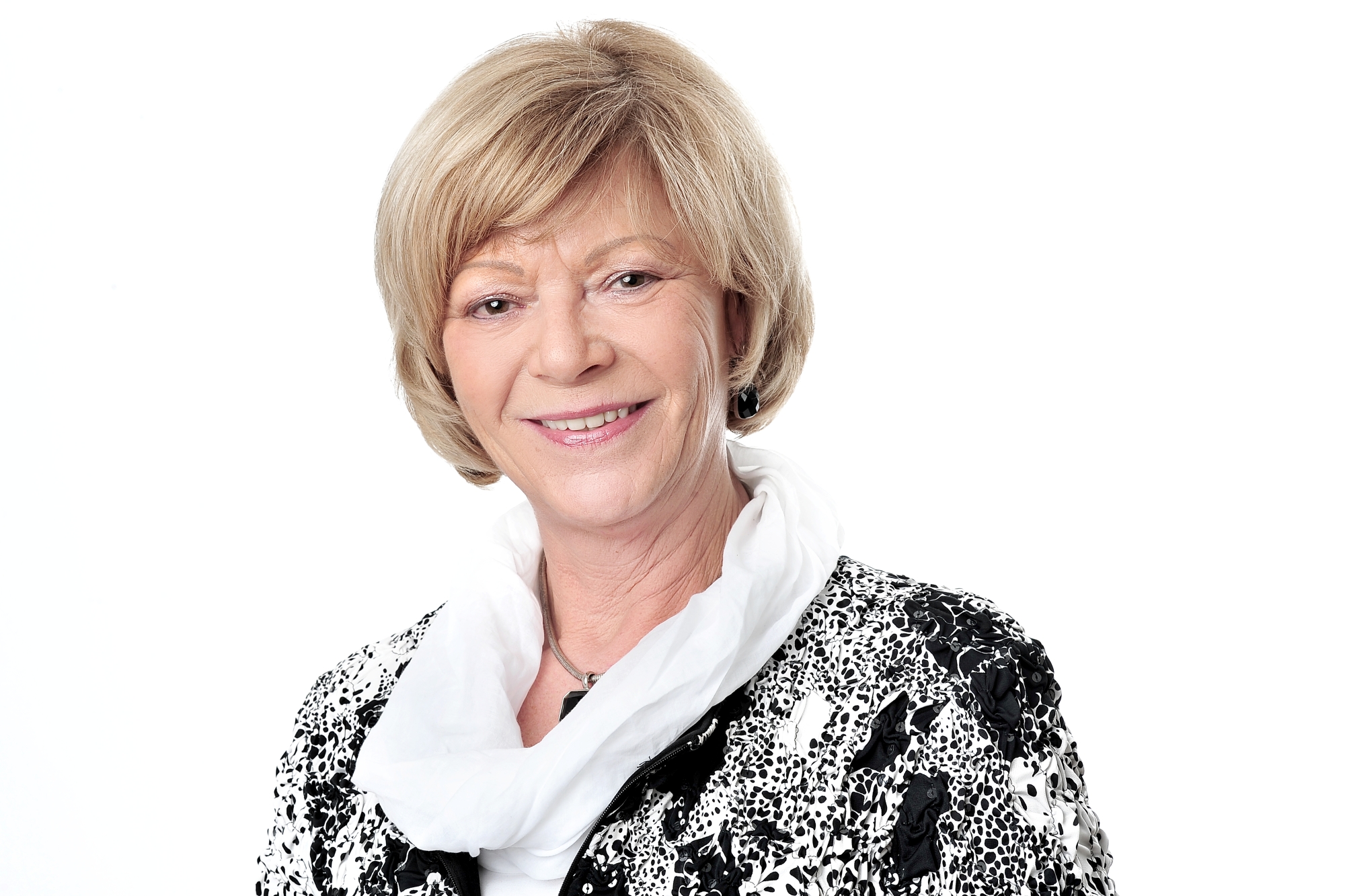 Porträt von Dr. Renate Reum: ältere Frau mit blonden mittellangen Haaren, schwarz-weißen Blazer und Halstuch